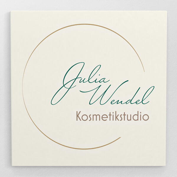 Logo Julia Wendel. Ein Kreis der rechts geöffnet ist. Innen steht Julia Wendel in geschwungener Schrift untereinander. Unten drunter auch im Kreis steht Kosmetikstudio in einer Serifenlosen Schrift. Der rest ist so angeordnet, dass er rechts aus dem Kreis raus sagt. An der Stelle wo das Logo offen ist.